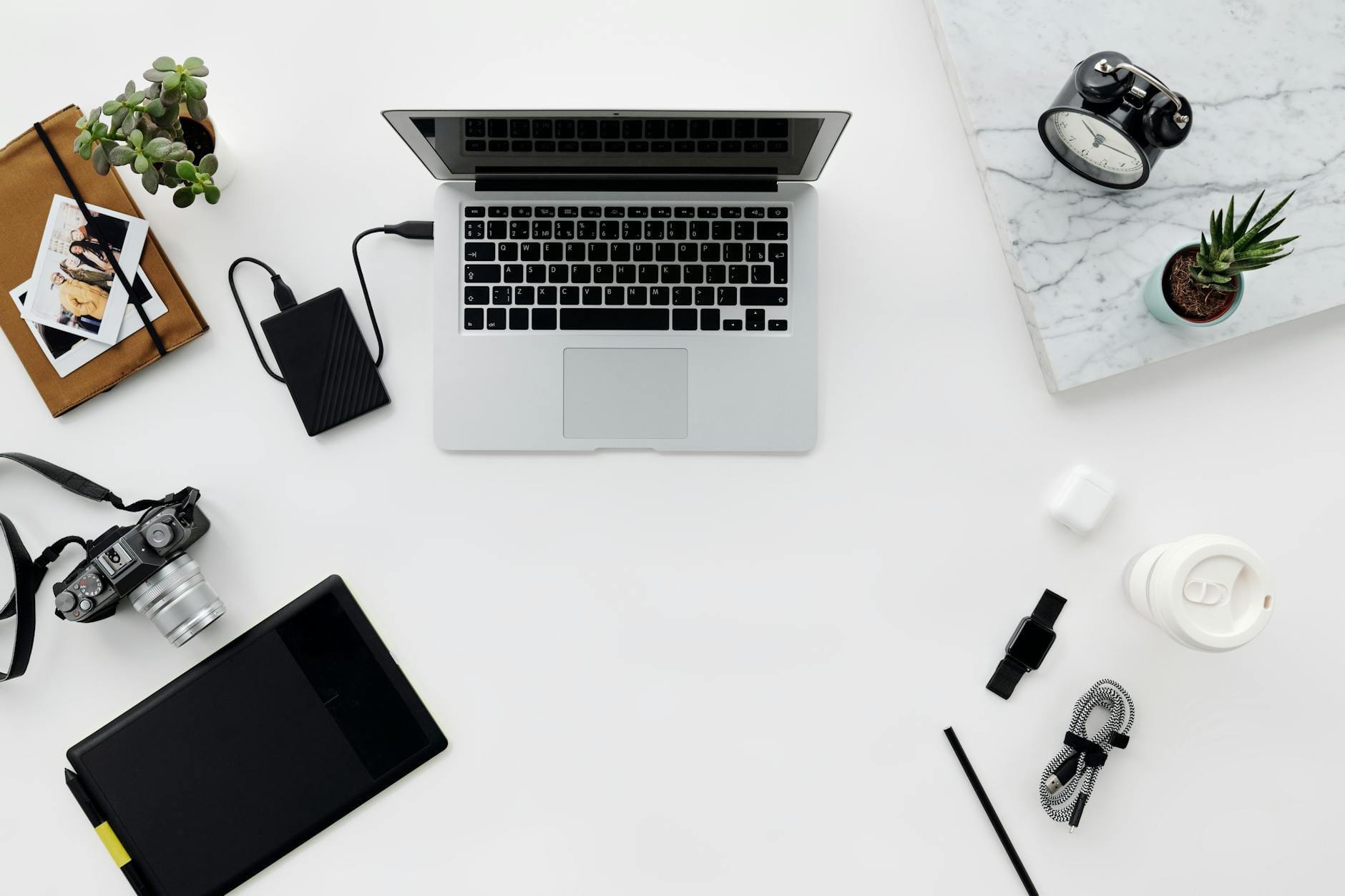 Minimalistyczne mobilne biuro z laptopem, aparatem i akcesoriami na biurku