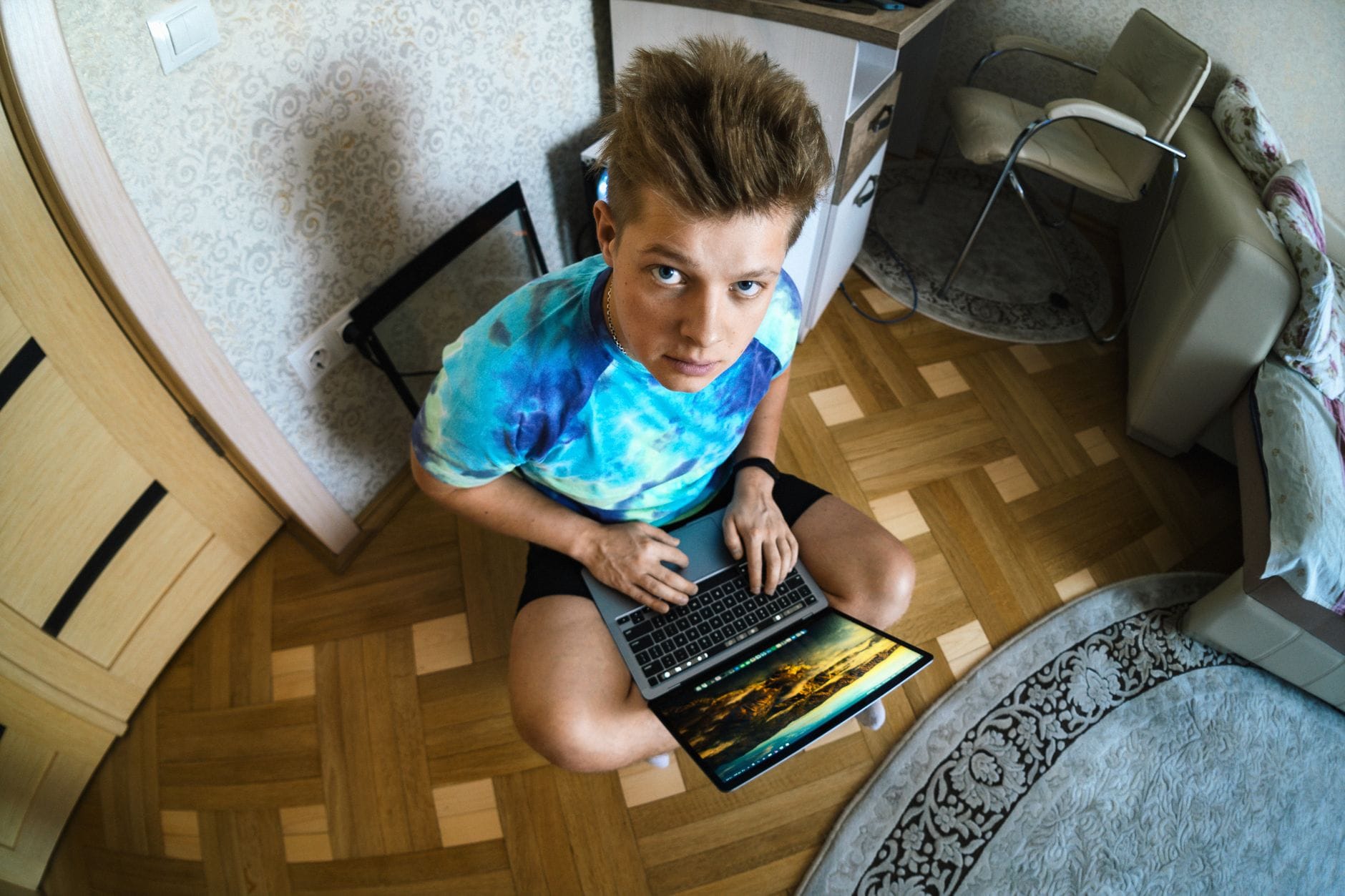 Nastolatek korzysta z laptopa w przytulnym pokoju, widok z góry