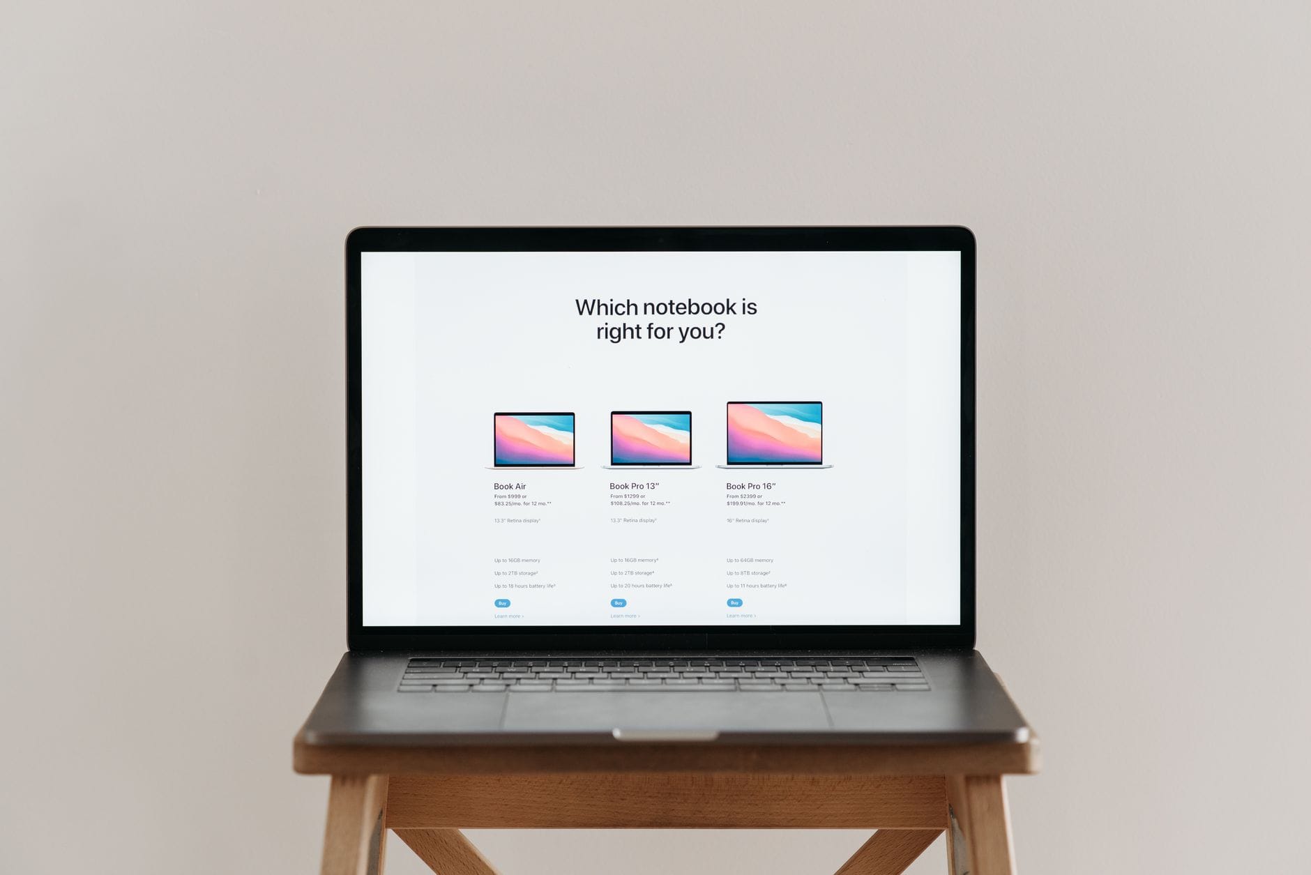 Otwarty laptop na drewnianym stołku z wykresem porównania notebooków